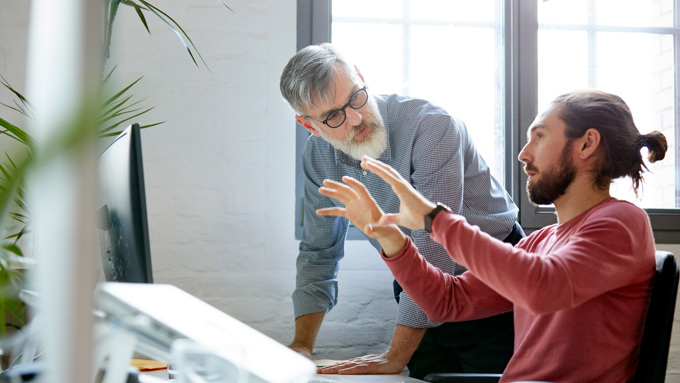 Forretningsmann som deler ideer med en kollega på kontoret