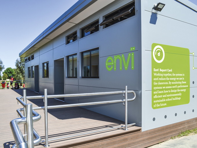 Moderne modulbasert skolebygning med små, åpne vinduer i ytterveggen, utstyrt med en rullestoltilgjengelig rampe.